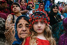 Femmes vêtues de vêtements traditionnels. Une vieille et une jeune regardent fixement l'appareil photo.