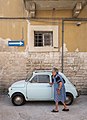 Image 602Old woman holding on to a Fiat 500 for support, Bari, Italy