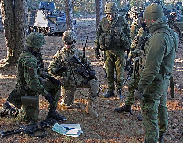 U.S. soldier guides Lithuanian Land Forces soldiers during joint military exercises in Rukla, Lithuania, October 2014