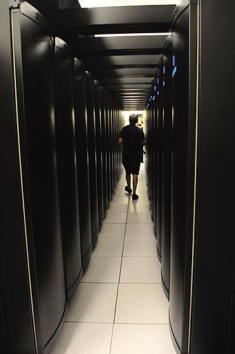 A person walking between the racks of a Cray XE6 Person walking between Hopper Cray XE6 racks.jpg