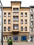 Apartment building with shop in closed development, with back building