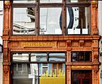 The T Gibson building in Long street, Cape Town is a two-storey building with a unique terracotta hard burnt clay finish. Designed by architect Anthony M de Witt, this building was originally occupied by Sellers Gents Outfitters, and later it became an art gallery. Current use: Commercial. T Gibson Building, 34 Long Street, Cape Town, detail 1.JPG