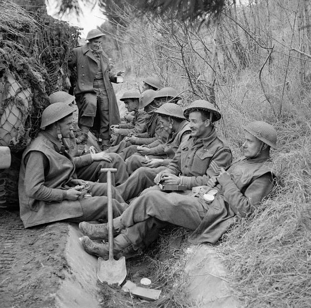 Men of the 1st Battalion, King's Shropshire Light Infantry eat a meal before going into action at Anzio, Italy, 31 January 1944.