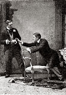 Young man in Victorian clothes reaching toward a cigarette case held by another similarly attired young man