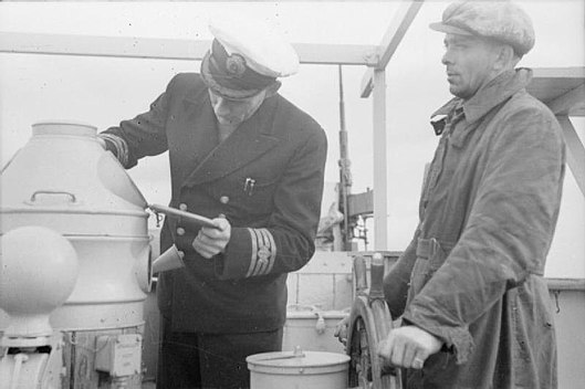 Befälhavaren på ett brittiskt fartyg i början på 1940-talet bär uniform med gradbeteck- ningar, medan rorsmannen bär civila kläder.