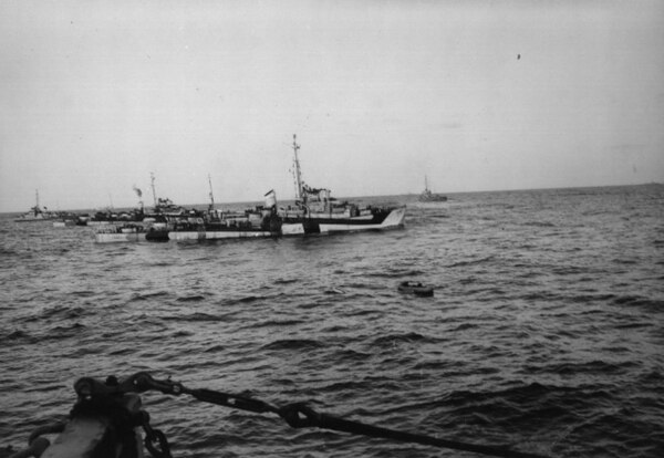 A life raft carrying U-546 survivors in the midst of U.S. Navy destroyer escorts on April 24, 1945