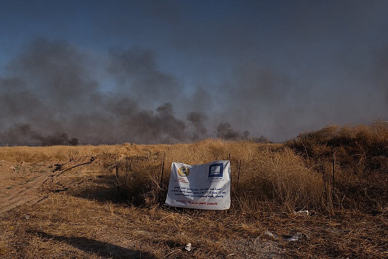 File:Views of the site of a massacre by the Islamic State and mass grave of Ezidis in Shingal (Sinjar) in summer of 2019 as field fires approach the location 05.jpg