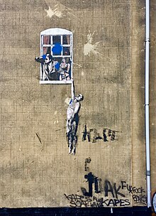 Well Hung Lover, the first legal street art in Great Britain, has been vandalized many times since its inception in 2006. Well Hung Lover, vandalised 2018.jpg