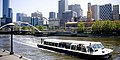 A flat boat is seen cruising along the Yarra River in Melbourne, Australia