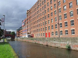 Cotton mill factory housing powered spinning or weaving machinery for the production of yarn or cloth from cotton