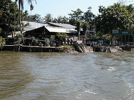 Cầu khỉ (monkey bridge) and small nước mắm (fish sauce) workshop on the bank of the Tiền River (branch of Mekong), Binh Dai District, Ben Tre Province, Vietnam
