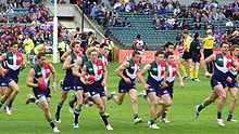 Fremantle players warming up prior to a game in the club's original guernsey, 2009 Fremantle players warming up prior to a game.jpg