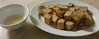 A dish of fried tofu (炸豆腐) with dipping sauce.