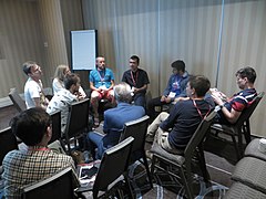 Kiril Simeonovski facilitating a group discussion on community building, while Cvetko Nedelkovski is patiently monitoring