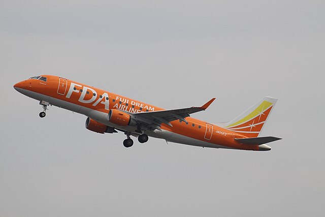 A Fuji Dream Airlines Embraer E170 in orange livery, all aircraft of the airline wear a different color scheme.