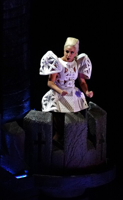 Lady Gaga performing "Judas" on the Born This Way Ball tour, standing on top of the medieval castle prop (2012)