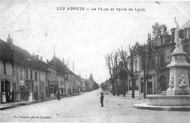 Ficheiro:Les Abrets, la place et route de Lyon en 1920, p 4 de L'Isère les 533 communes - photo F. Vialatte, Oyonnax.tiff