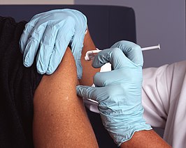 Een verpleegkundige zet een inenting