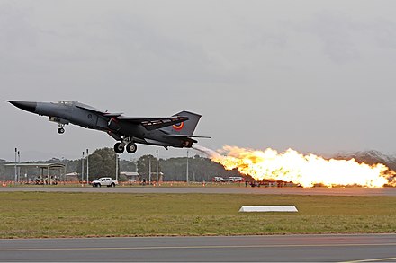A Royal Australian Air Force F-111C performing a dump-and-burn, a procedure where the fuel is intentionally ignited using the aircraft's afterburner.