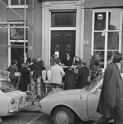 Redaktie van Folia Civitatis werkt op de stoep voor Instituut voor Perswetenschap aan de Turfmarkt 151 te Amsterdam wegens sluiting instituut (24 februari 1970)