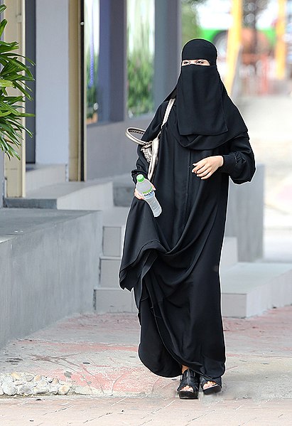Muslim woman in Saudi Arabia wearing a plain-cloth black niqab