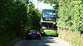 English: Southern Vectis 1145 Reeth Bay (HW09 BBZ), a Scania OmniCity, in Pixley Hill, Norton Green, Isle of Wight. Pixley Hill is a narrow road, and the local NIMBYs have complained about buses using the road. The problem can be seen here, the bus having met a car, and the two being unable to pass. The bus then had to wait while the car reversed out of the way. However, in reality it is no different to many other island roads that are served by buses.