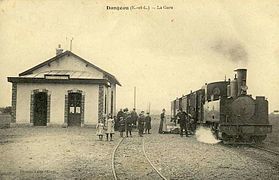 Postkarte von 1910 mit einem Zug der Dampflokomotive Nr. 13 und einigen Passagieren am Bahnhof Dangeau, dessen Architektur die des zweiten Netzes ist