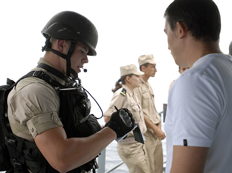 File:U.S. Navy Gunner's Mate 2nd Class Clifford Borgstedt, a member of the visit, board, search and seizure team with the dock landing ship USS Whidbey Island (LSD 41), interviews a Romanian sailor playing the role 110802-N-GH121-151.jpg