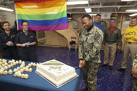 U.S. Sailors gather for cake during a Lesbian, Gay, Bisexual and Transgender Pride Month observance aboard the amphibious assault ship USS Tripoli (LHA-7) June 22, 2021, in the Pacific Ocean.