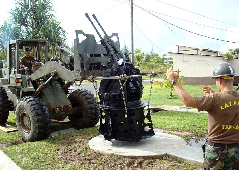 File:US Navy 081017-N-1013S-001 Equipment Operator 2nd Class Ted Hillanbrand directs Equipment Operator 1st Class Gregory Johannsen as they place a World War II era anti-aircraft gun in front of the flagpole at Camp Katuu.jpg