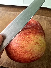 Shaving the synthetic wax from an apple Waxed apple.jpg