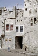 منزلان في قلعة القطيف يتكونان من 3 طوابق يصل ممر فيما بينهما، وتحتهما ساباط، تعود الصورة لعام 1975م.