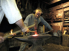 An artist blacksmith and a striker working as one 3 tourist helping artist blacksmith in finland.JPG