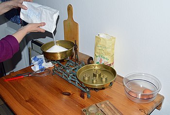 White sugar being weighed for a cake Abwaage der Zutaten.JPG