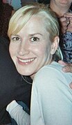 Photo d'une femme vue de profil en train de sourire.