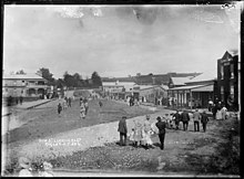 Bow St in 1911 - of these buildings, only those on the far left (Harbour View Hotel) and right (skate shop and ULO) remain, plus the building in the middle distance on the right (Shack). The street retains a grassy centre, but the roads now occupy most of it. Bow Street looking east, Raglan, 1911 - Photograph taken by Gilmour Brothers (21312007349).jpg