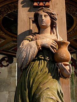 A wood carving, an allegory for "Temperance", on one of the five pillars supporting the baldachin.