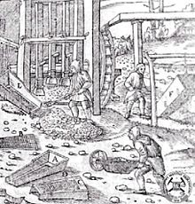 Ore stamp mill (behind worker taking ore from chute). From Georg Agricola's De re metallica (1556) Gal gromadzenie urobku.jpg