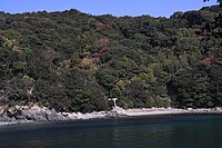 加布良古崎 （かぶらこざき） 画像中央付近の海岸に一の鳥居が見える。社殿は岬の頂に鎮座する。