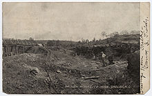 Postcard view of a monazite mine in Shelby, North Carolina, showing cart tracks and a bridge Monazitemineshelbync.jpg