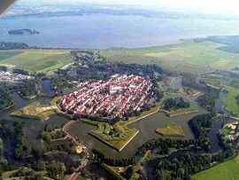 Aerial view of the fortified town of Naarden; with a good view of the star-shaped layout of the earth bastions, designed in the early gunpowder age to place outward guns to force an enemy to keep distance and thus to protect the town proper against shelling Naarden kl.JPG