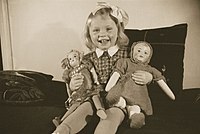 Smějící se holčička se svými panenkami