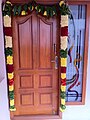 Коробка парадной двери дома украшена гирляндой (Нила Маалаи) во время новоселья в Тамилнаде