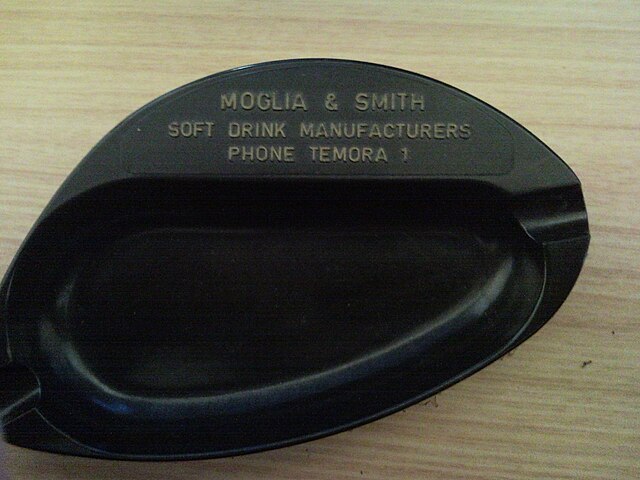 An old bakelite ash tray showing an example of a single digit phone number used in the early days of telecommunication.