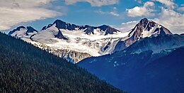 Left to right: Mount Fitzsimmons, Overlord Mountain, and Fissile Peak Overlord Mountain over forest.jpg