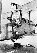 Flieger im militärischen Doppeldecker mit am Rumpf montierter Kamera