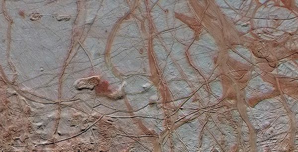 Linear fractures on Europa's surface, likely colored by tholins.