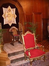 Throne of the Ecumenical Patriarch of Constantinople in the Phanar, Istanbul. On the dais the Gospel is enthroned on a curule chair, in front of it, lower down is the patriarch's throne. Patriarch of Constantinople throne.jpg