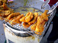 Indonesian roadside gorengan (fritter) peddler offering pisang goreng. Pisang goreng in a basket.jpg