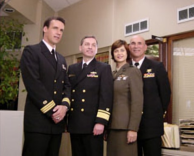 The then-Judge Advocate General of the Navy, Rear Admiral Donald J. Guter (second from left), visiting the set, meeting with the cast during the shoot